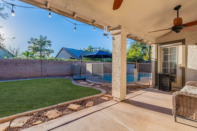 view of patio / terrace with a fenced in pool, a fenced backyard, and a ceiling fan