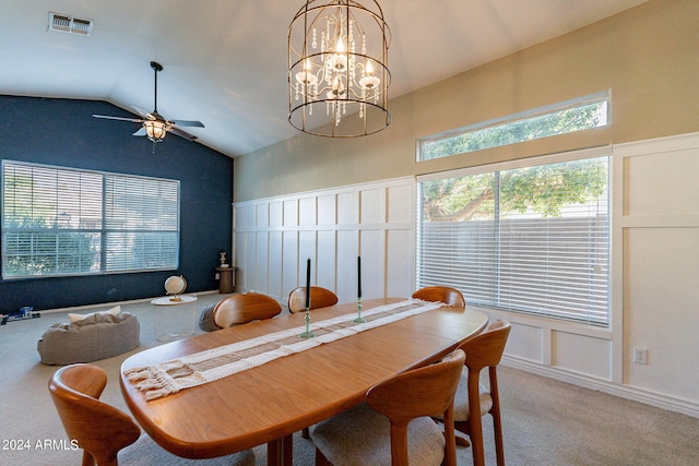 dining space featuring vaulted ceiling, ceiling fan with notable chandelier, light colored carpet, and plenty of natural light