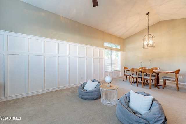 sitting room featuring an inviting chandelier, light colored carpet, and lofted ceiling