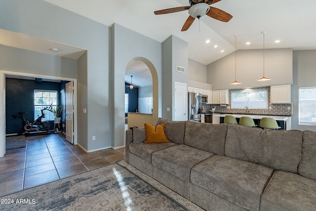 living area with arched walkways, plenty of natural light, high vaulted ceiling, and visible vents