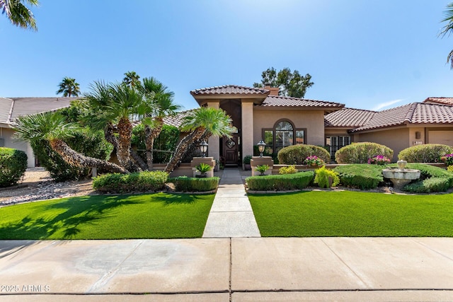 mediterranean / spanish-style house with a front yard, a tiled roof, and stucco siding