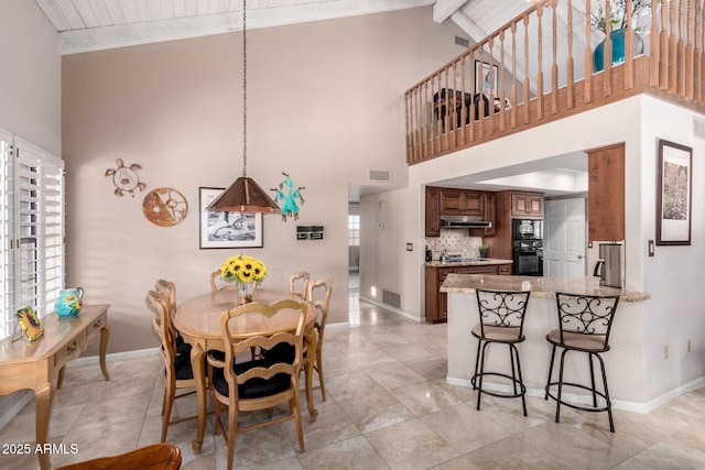 dining room featuring beamed ceiling, visible vents, baseboards, and high vaulted ceiling