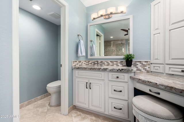 bathroom with decorative backsplash, toilet, vanity, and tiled shower