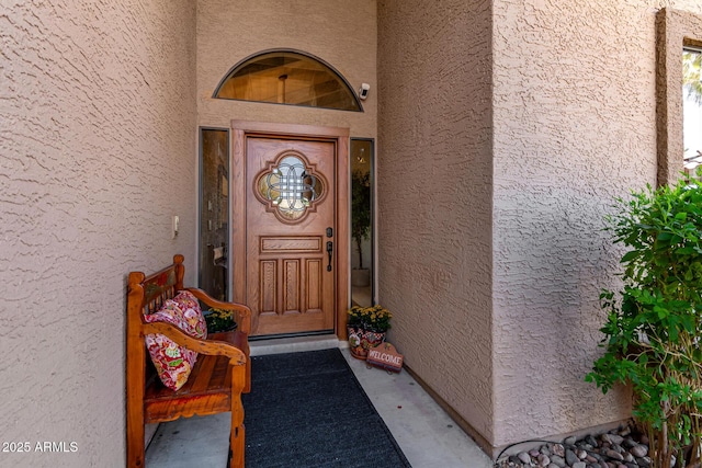 view of exterior entry with stucco siding