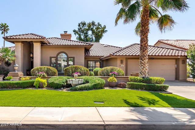 mediterranean / spanish house featuring a front yard, stucco siding, a chimney, a garage, and driveway