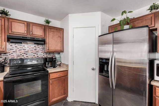 kitchen with tasteful backsplash, black range with electric stovetop, light countertops, under cabinet range hood, and stainless steel refrigerator with ice dispenser