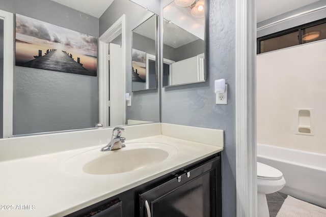 full bathroom with toilet, tile patterned floors, a textured wall, and vanity