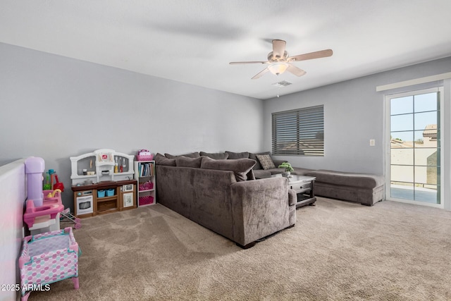 living room featuring carpet flooring, visible vents, and a ceiling fan