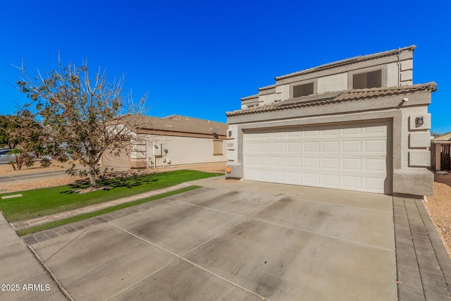 view of front of house with driveway, a tiled roof, and stucco siding