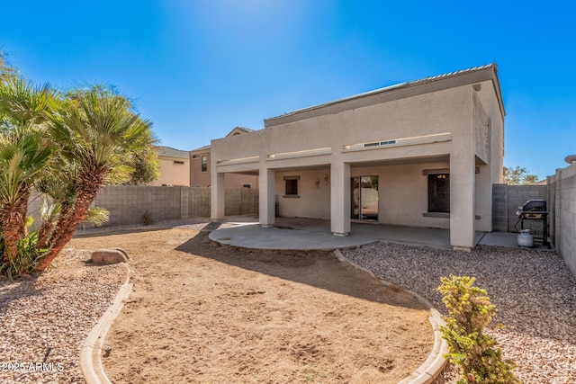 back of house with a patio area, a fenced backyard, and stucco siding