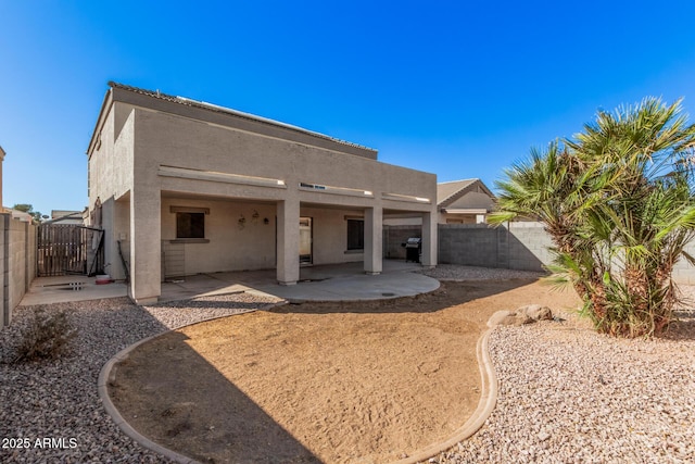 rear view of property with a patio area, a fenced backyard, and stucco siding