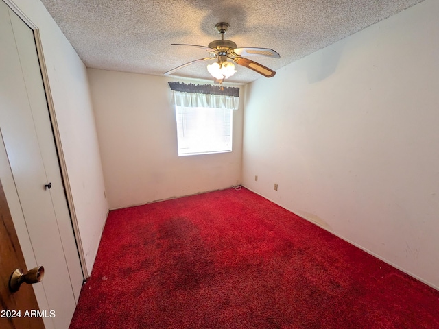 carpeted spare room featuring a textured ceiling and ceiling fan