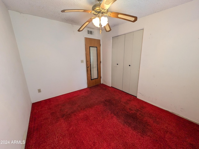 unfurnished bedroom with carpet floors, a closet, visible vents, and a textured ceiling