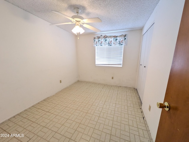 unfurnished room featuring ceiling fan and a textured ceiling