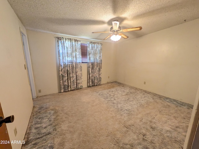 spare room featuring a ceiling fan, carpet, and a textured ceiling