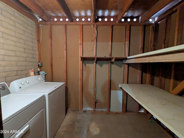 laundry area with washing machine and dryer, laundry area, and brick wall