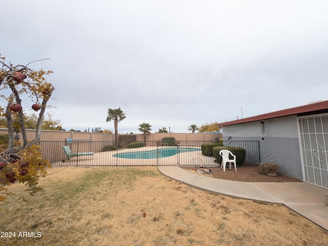 view of swimming pool with a fenced in pool, fence, a patio, and a lawn