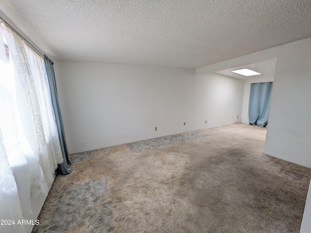 spare room featuring carpet and a textured ceiling