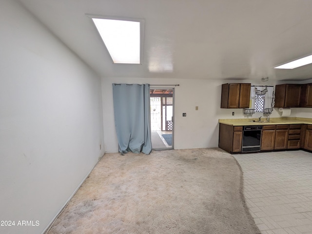 kitchen featuring light carpet, a sink, light countertops, and dishwasher