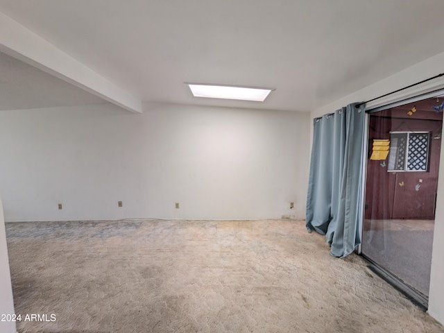 empty room featuring carpet flooring and lofted ceiling with beams