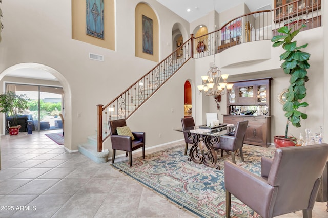 2383 E Zion Way, Chandler, AZ 85249 - living room with arched walkways, a chandelier, stairs, a high ceiling, and tile patterned floors
