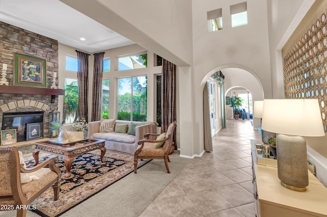 2383 E Zion Way, Chandler, AZ 85249 - living area featuring light tile patterned flooring, a high ceiling, arched walkways, and a fireplace