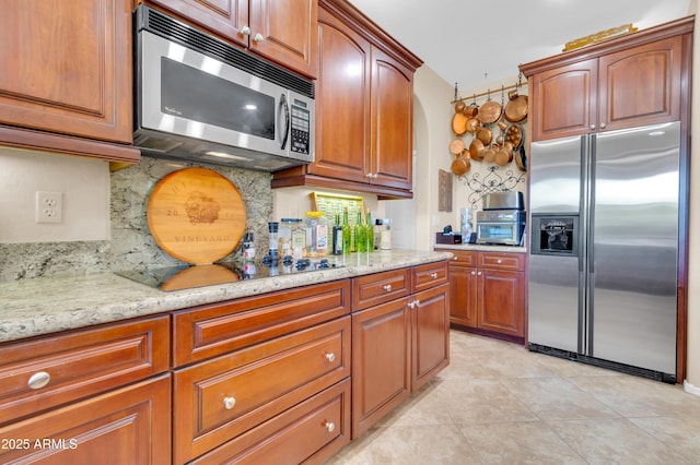 2383 E Zion Way, Chandler, AZ 85249 - kitchen with stainless steel appliances, tasteful backsplash, light stone countertops, light tile patterned floors, and brown cabinetry