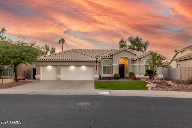 mediterranean / spanish house featuring a yard and a garage