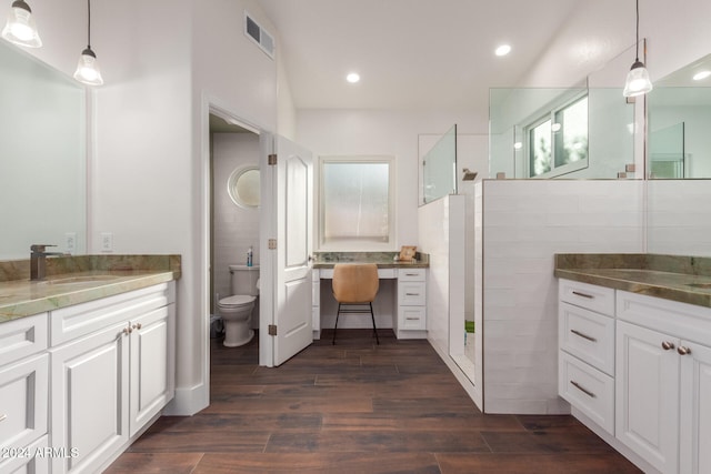 bathroom featuring a shower, vanity, wood-type flooring, and toilet