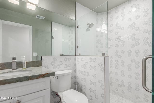 bathroom featuring toilet, vanity, and walk in shower