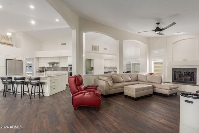 living room featuring ceiling fan, dark hardwood / wood-style flooring, and high vaulted ceiling