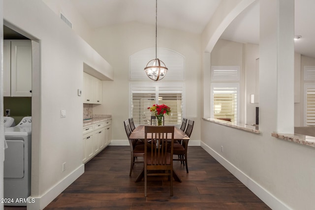 dining space featuring washer and clothes dryer, dark hardwood / wood-style flooring, lofted ceiling, and a notable chandelier