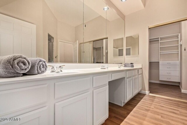8245 E Bell Rd Unit 133, Scottsdale, AZ 85260 - bathroom featuring a spacious closet, double vanity, a sink, and wood finished floors