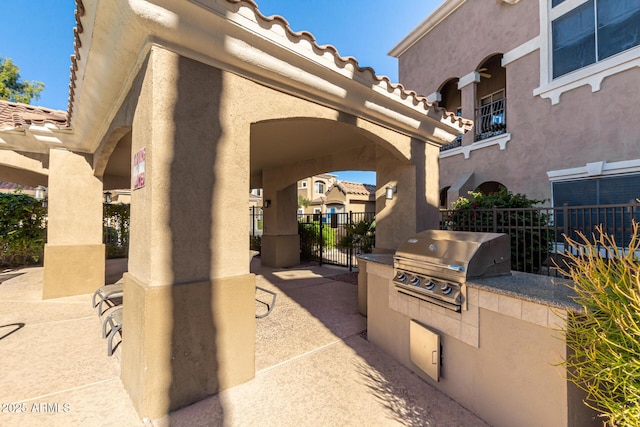 8245 E Bell Rd Unit 133, Scottsdale, AZ 85260 - view of patio featuring exterior kitchen, grilling area, fence, and a gate