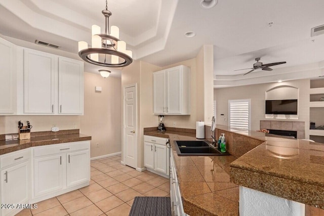 8245 E Bell Rd Unit 133, Scottsdale, AZ 85260 - kitchen featuring visible vents, white cabinets, a raised ceiling, open floor plan, and tile counters