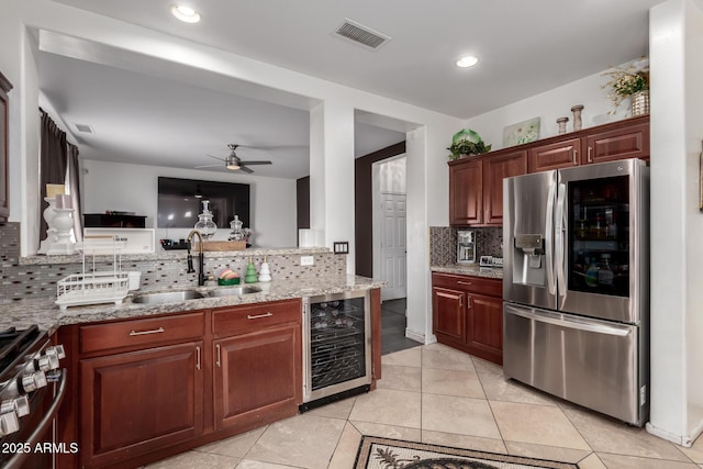 kitchen with visible vents, ceiling fan, beverage cooler, stainless steel appliances, and a sink