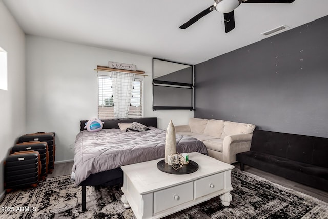 bedroom featuring visible vents, a ceiling fan, and wood finished floors