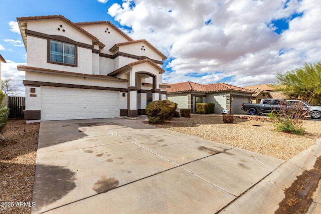 mediterranean / spanish home with stucco siding, driveway, a tile roof, and an attached garage