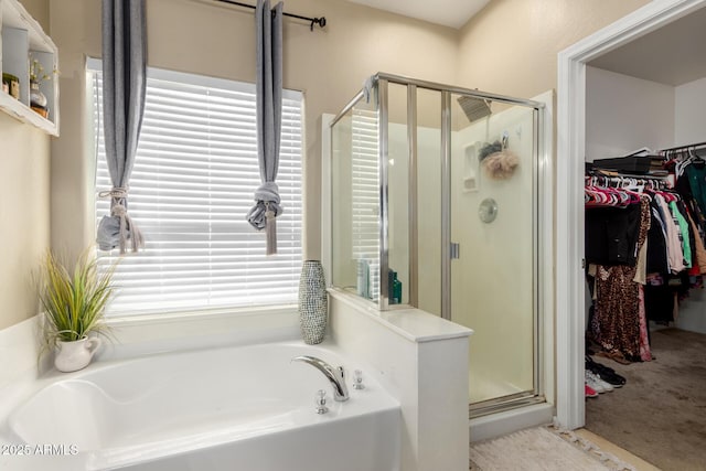 full bathroom featuring a bath, a stall shower, and a walk in closet