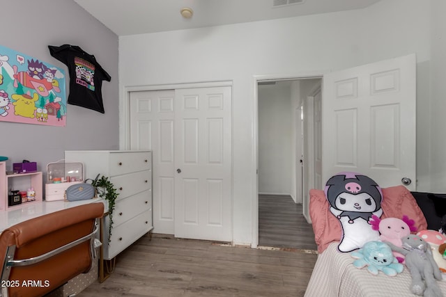 bedroom with a closet, visible vents, and wood finished floors