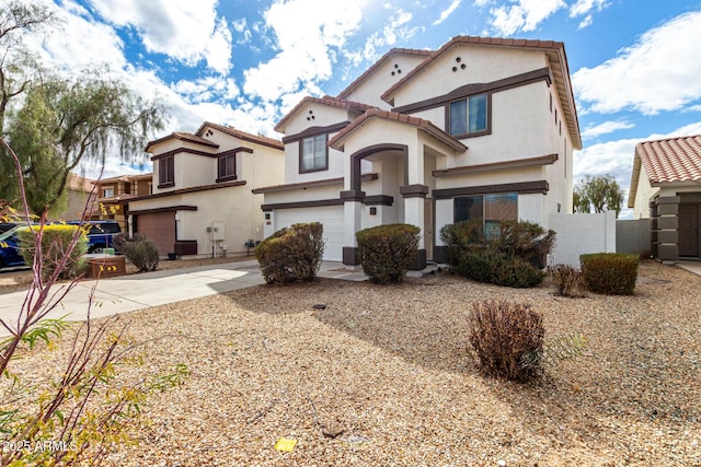 view of front of property featuring a tiled roof, stucco siding, driveway, and a garage