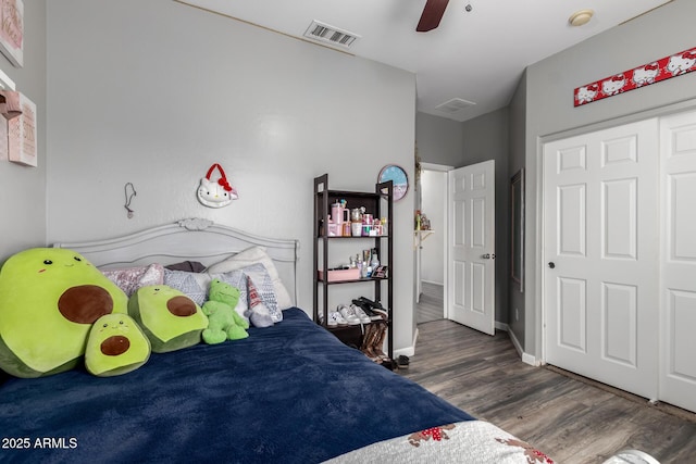 bedroom featuring visible vents, baseboards, ceiling fan, and wood finished floors