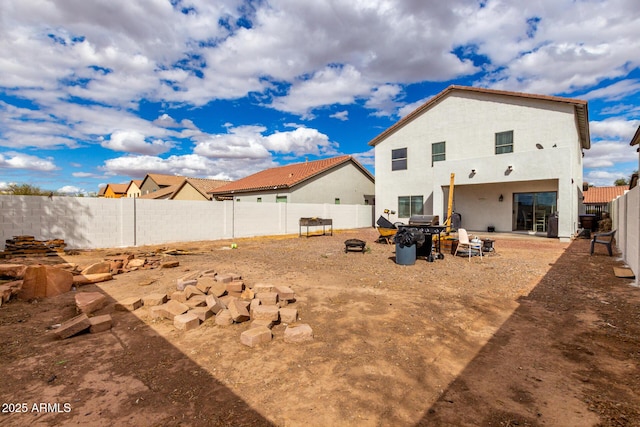 back of property with stucco siding and a fenced backyard