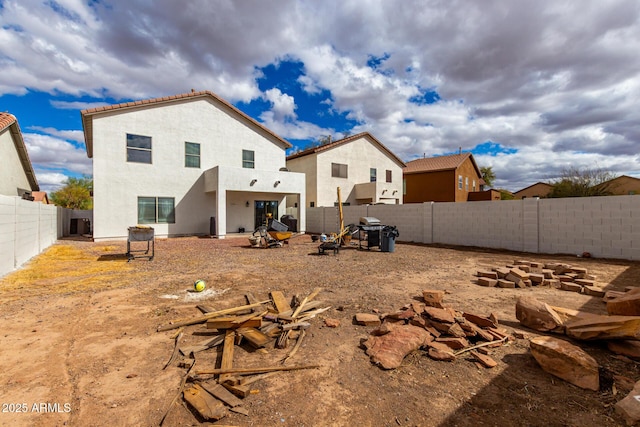 back of house featuring stucco siding and a fenced backyard