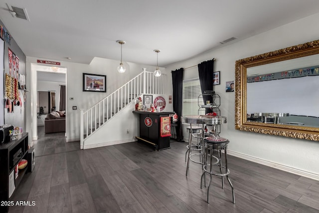 dining space featuring visible vents, dark wood finished floors, and stairway