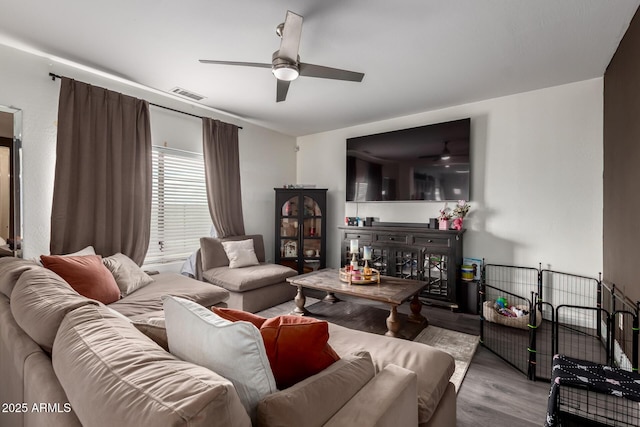 living area with visible vents, wood finished floors, and ceiling fan