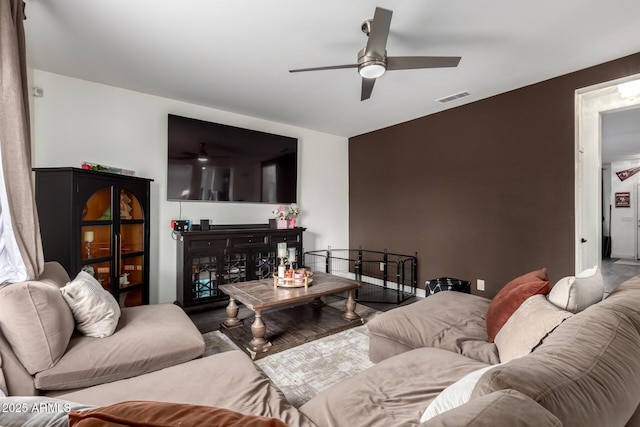 living room with visible vents, baseboards, ceiling fan, and wood finished floors