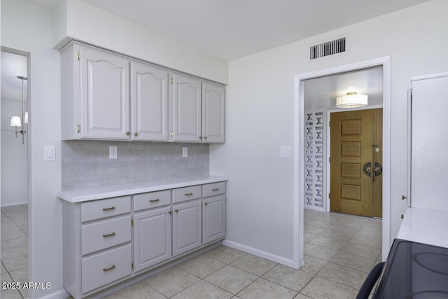 kitchen with gray cabinetry, range with electric stovetop, light tile patterned floors, and backsplash