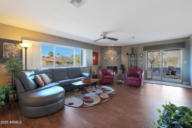 living room featuring dark hardwood / wood-style floors, ceiling fan, and a fireplace