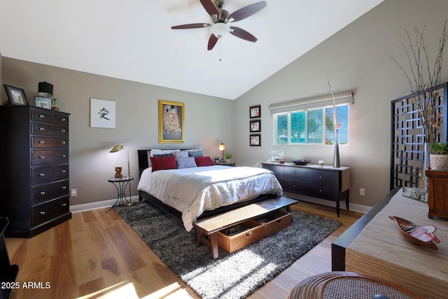 bedroom featuring ceiling fan, light hardwood / wood-style floors, and vaulted ceiling